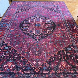 May include: A rectangular area rug with a detailed, geometric pattern in shades of burgundy, black, blue, and orange. The rug features a central medallion design and intricate border patterns, suitable for home decor.
