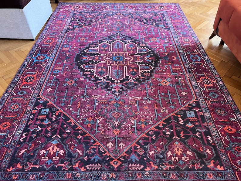 May include: A rectangular area rug with a detailed, geometric pattern in shades of burgundy, black, blue, and orange. The rug features a central medallion design and intricate border patterns, suitable for home decor.