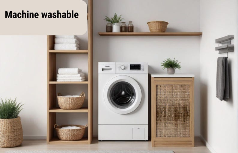 May include: A modern laundry room with a white washing machine, wooden shelving, and a woven cabinet. The shelves hold white towels and wicker baskets. The text "Machine washable" is displayed.