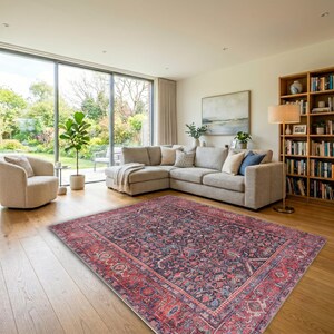 May include: A rectangular area rug featuring a dark navy blue center with intricate floral and vine patterns in shades of red, pink, and cream, surrounded by a wide, ornate border in deep red with matching floral motifs and geometric details.