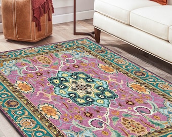 May include: A rectangular area rug featuring a vibrant magenta background with a central teal and black floral medallion. The border displays a repeating pattern of teal, orange, and dark brown floral motifs, creating a detailed and colorful design.