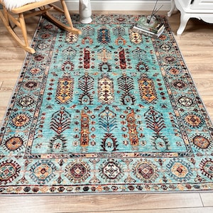 May include: A teal blue rug with a traditional Persian design. The rug features intricate patterns in shades of red, orange, yellow, and brown.