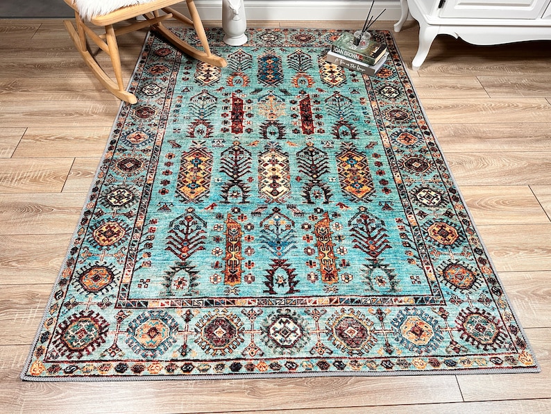 May include: A teal blue rug with a traditional Persian design. The rug features intricate patterns in shades of red, orange, yellow, and brown.