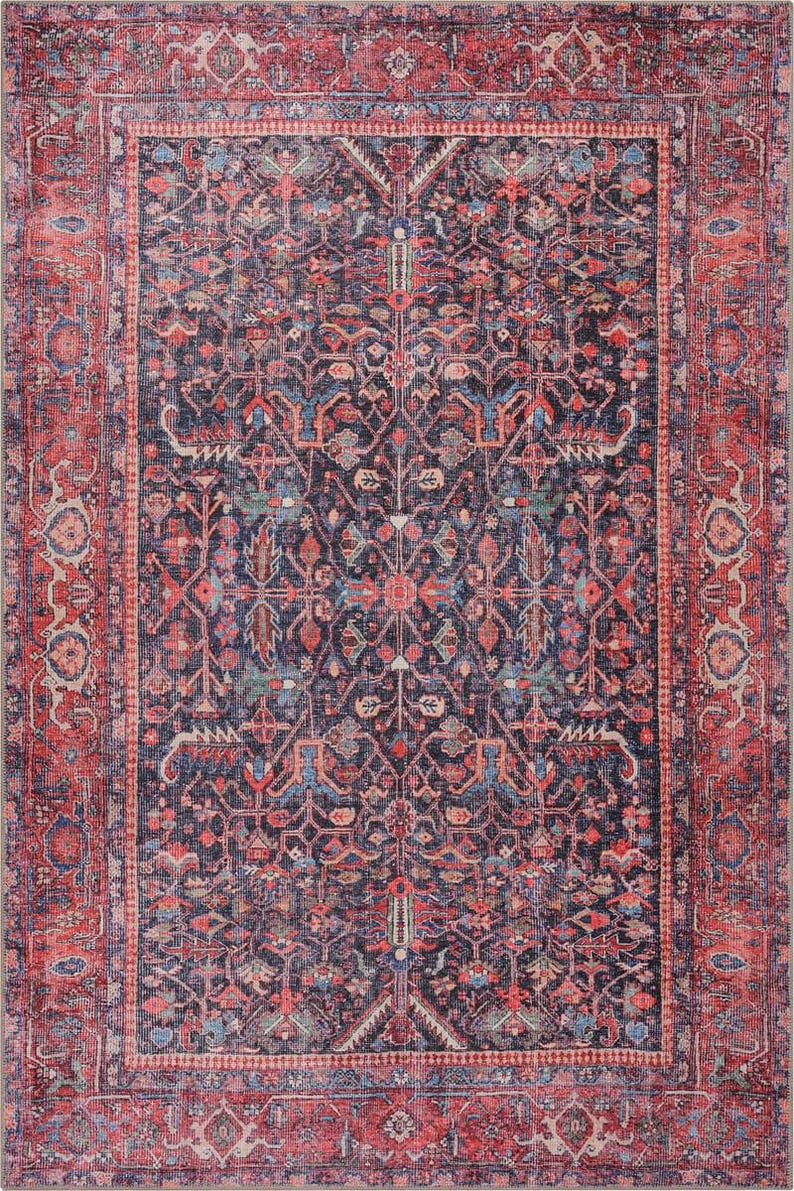 May include: A rectangular area rug featuring a dark navy blue center field with a symmetrical floral and geometric pattern in shades of red, light blue, and cream. The rug has a wide, ornate border in deep red with matching floral motifs.