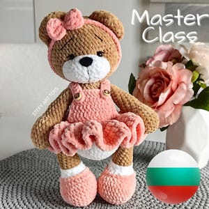 May include: A crocheted brown teddy bear wearing a pink dress with a bow on its head. The bear is standing on a white surface with a Bulgarian flag in the background. The text "Master Class" is visible in the upper right corner of the image.