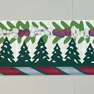 May include: A white and green Christmas-themed border with a repeating pattern of green leaves, white flowers, red berries, and dark green trees. The border has a red and white striped pattern at the bottom.