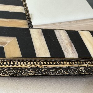 Detailed close-up of the bone inlay texture and ornate gold brass trim surrounding the mirror edge moroccan mirror.
