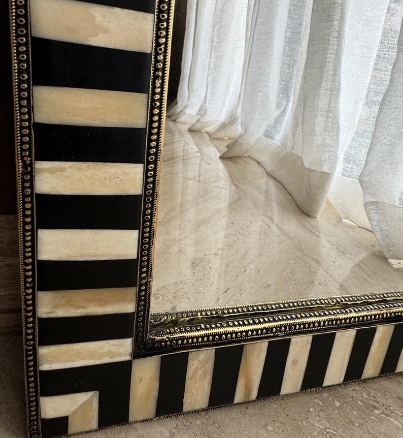 Handcrafted bone inlay mirror styled with home decor accessories in a modern bohemian living room.