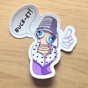 May include: A die-cut sticker featuring a cartoon character with a wooden post body, large blue eyes, and a grey bucket on its head. The character wears a purple robe with a white collar featuring black hearts and holds up one finger. Text reads BUCK-ET!