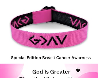 May include: A pink fabric wristband with a black interior and a black plastic buckle. The text "October Special", "Special Edition Breast Cancer Awarness", and "God Is Greater Than the Highs and Lows" appear with the symbol "G>AV" in black.