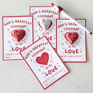 Op de afbeelding: Vier Valentijnsdagkaarten met rode randen en witte binnenkanten. Elke kaart heeft een rood hart met de tekst "Gods grootste gebod is om lief te hebben" en een chocoladehartje. De kaarten bevatten ook de tekst "Gelukkige Valentijnsdag" en "Van:"