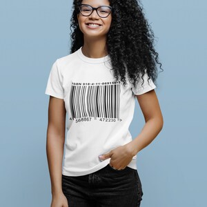 K&ouml;nnte beinhalten: Ein wei&szlig;es T-Shirt mit einer schwarzen Barcode-Grafik und dem Text "ISBN 918-4-11-869156-1" auf der Vorderseite. Der Barcode hat die Zahlen 568867 und 472230 darunter gedruckt.
