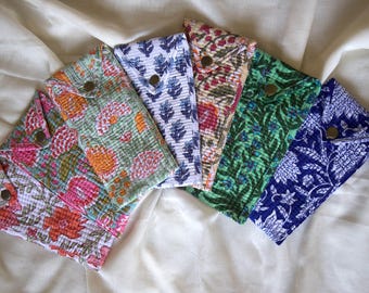 May include: Seven fabric pouches with floral and leaf patterns in shades of pink, orange, green, and blue. Each pouch has a metal snap closure. The pouches are displayed on a white fabric surface, showcasing their diverse designs.