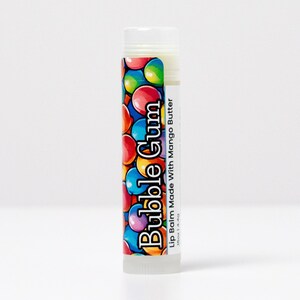May include: A lip balm tube with a white cap and a label featuring colorful bubble-like graphics. The label reads "Bubble Gum" and "Lip Balm Made With Mango Butter". The product is designed for lip care.