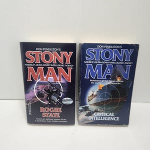 May include: Two paperback books titled "Stony Man" by Don Pendleton. The book on the left is "Rogue State" with a dark cover featuring a helicopter. The book on the right is "Critical Intelligence" with a blue cover and a ship illustration.