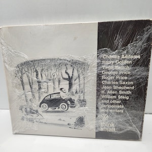 Puede incluir: Una portada de álbum vintage con una ilustración en blanco y negro de un coche pequeño con una persona dentro, conduciendo por un bosque. La portada incluye el texto "think small" y enumera varios dibujantes y escritores.