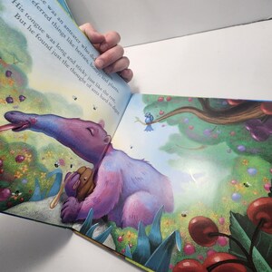 Puede incluir: Ilustraci&oacute;n de un libro infantil con un oso hormiguero morado con una larga lengua, rodeado de cerezas y flores. El texto dice: "&Eacute;rase una vez un oso hormiguero que... Prefer&iacute;a cosas como bayas, miel y plantas."