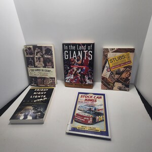 Pode incluir: Uma coleção de livros com capas variadas. Os títulos incluem "The Games Do Count", "In the Land of Giants", "Stubs: A Father's Tickets", "Friday Night Lights" e "Stock Car Kings."