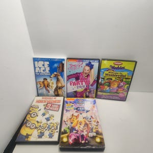 Op de afbeelding: Een verzameling van vijf dvd-hoesjes voor kinderen met Ice Age The Meltdown, JoJo Siwa Party Pack, Weebles Welcome to Weebleville, Despicable Me Minion Madness en Paw Patrol Jet to the Rescue, allemaal samen op een plat oppervlak geplaatst.