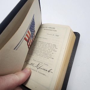 May include: An open book with a black cover, featuring a printed letter from The White House, Washington, dated January 25, 1941. The letter is signed by Franklin D. Roosevelt. An illustration of the American flag is visible.