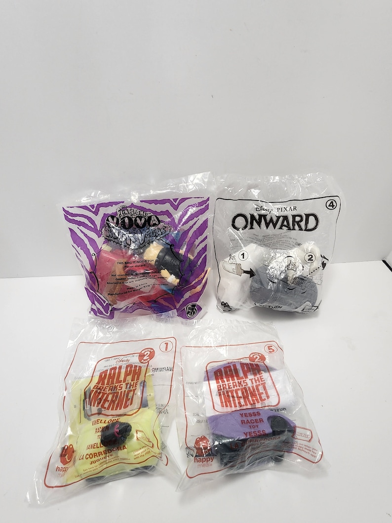 Puede incluir: Cuatro bolsas de pl&aacute;stico que contienen juguetes Happy Meal de las pel&iacute;culas de Disney Pixar. Las bolsas est&aacute;n etiquetadas con los t&iacute;tulos de las pel&iacute;culas: "Onward", "Ralph rompe Internet" y "Moana". Los juguetes son visibles a trav&eacute;s de las bolsas de pl&aacute;stico.