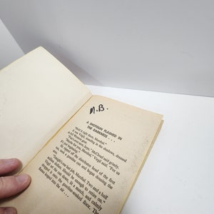 May include: A close-up of a book page with the text "A SHOTGUN FLASHED IN THE DARKNESS..."  The text continues with a story about a group of men in a Western setting.  The text reads "Hold it right there, Marshal."  "It was Virgil, standing in the shadows, dressed in full Western gear."  "Fun's over now, boys," McCloud said grimly.  "Maybe for you, Marshal," Virgil said.  "For us it's just beginning."