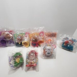 May include: A set of eight plastic toy figures in individual clear plastic bags. The figures are colorful and feature characters from the children's television show "The Backyardigans".