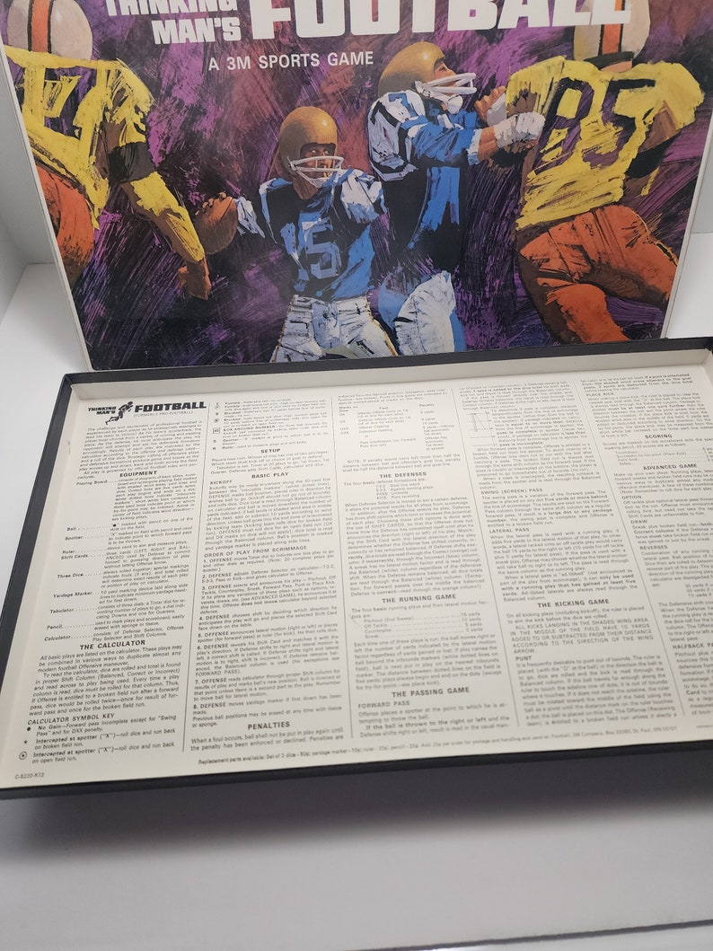 Peut inclure: Une bo&icirc;te de jeu de soci&eacute;t&eacute; vintage avec une illustration color&eacute;e de joueurs de football sur le devant. Le dos de la bo&icirc;te montre les r&egrave;gles et les instructions du jeu. Le jeu s'appelle "Thinking Man's Football" et est un jeu de sport 3M.