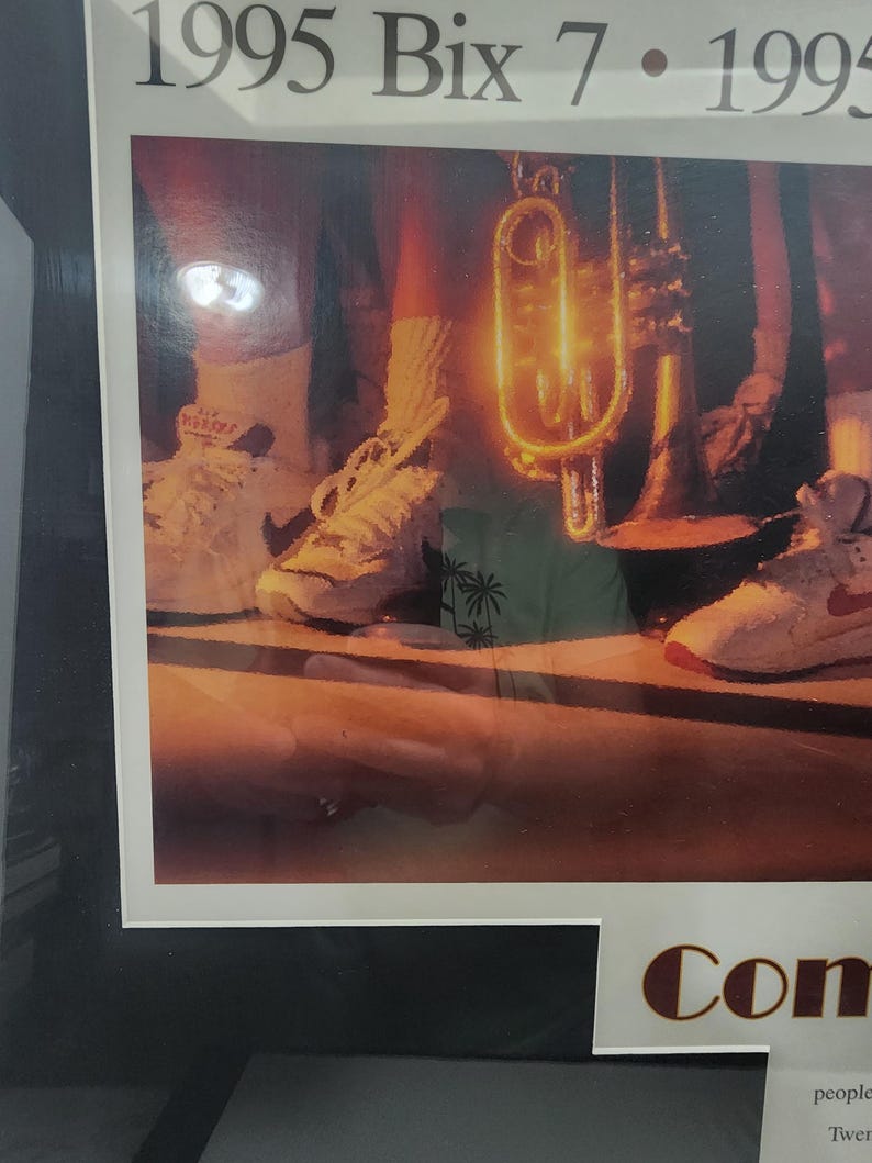Peut inclure: Photographie encadr&eacute;e avec le texte "1995 Bix 7". L'image pr&eacute;sente une trompette et des baskets. Les baskets sont blanches avec des accents rouges. La photographie est dans un cadre noir.