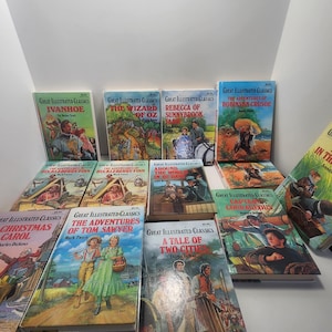 May include: A collection of vintage "Great Illustrated Classics" books. Titles include "Ivanhoe," "The Wizard of Oz," "Rebecca of Sunnybrook Farm," and "The Adventures of Robinson Crusoe." The books feature colorful illustrations and are arranged on a surface.