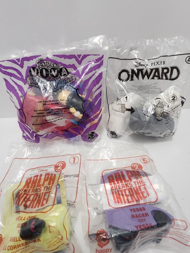 Puede incluir: Una colecci&oacute;n de cuatro bolsas de pl&aacute;stico que contienen juguetes de personajes de Disney. Las bolsas son de las pel&iacute;culas "Onward", "Ralph rompe Internet" y "Los Picapiedra y WWE: &iexcl;Choque en la Era de Piedra!" Cada bolsa presenta un personaje diferente de la pel&iacute;cula. Las bolsas son todas amarillas y tienen el logotipo de Disney.