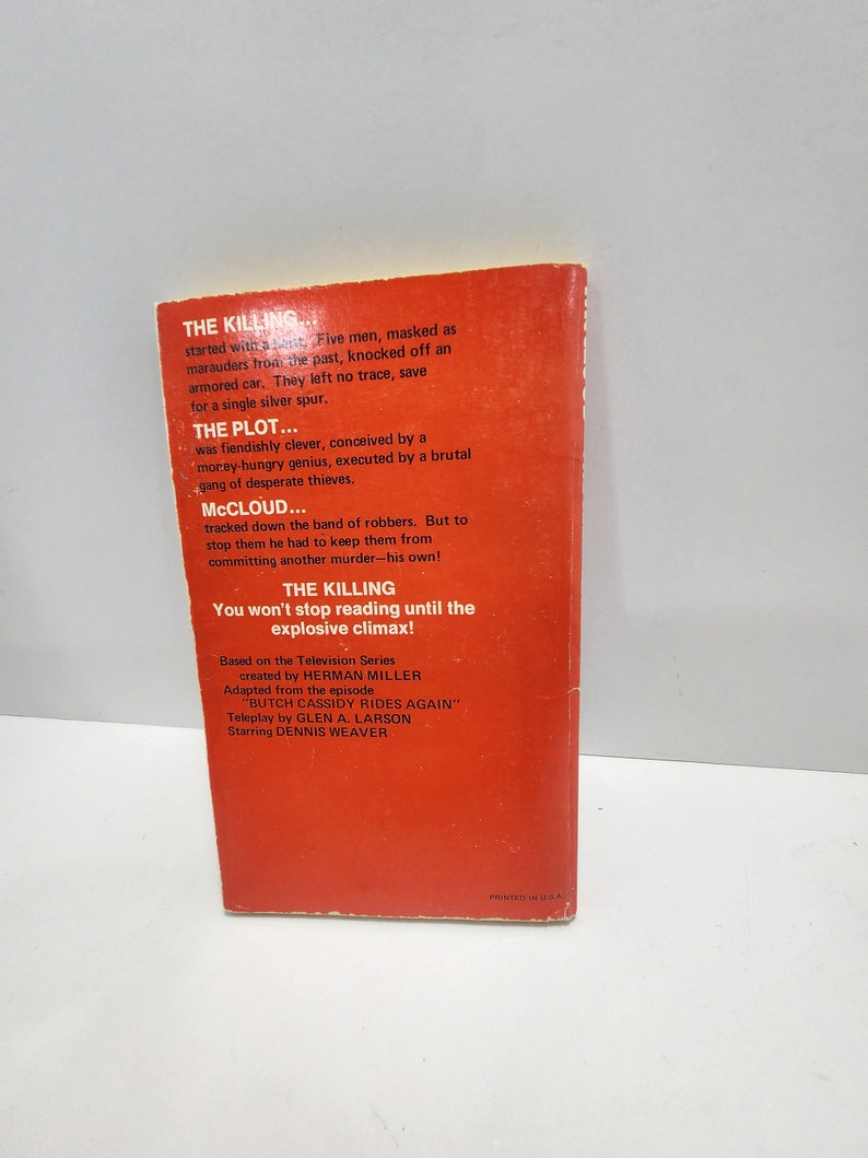 May include: A red paperback book cover with the title "The Killing" and the text "You won't stop reading until the explosive climax!"  The book is based on the television series "McCloud" created by Herman Miller. The episode is "Butch Cassidy Rides Again" with a teleplay by Glen A. Larson and starring Dennis Weaver.