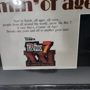 Peut inclure: Impression encadr&eacute;e avec le texte "men of age" en marron. L'impression comprend du texte sur la course Bix 7, avec le nom de la course et la date, le 29 juillet 1995, bien en &eacute;vidence.