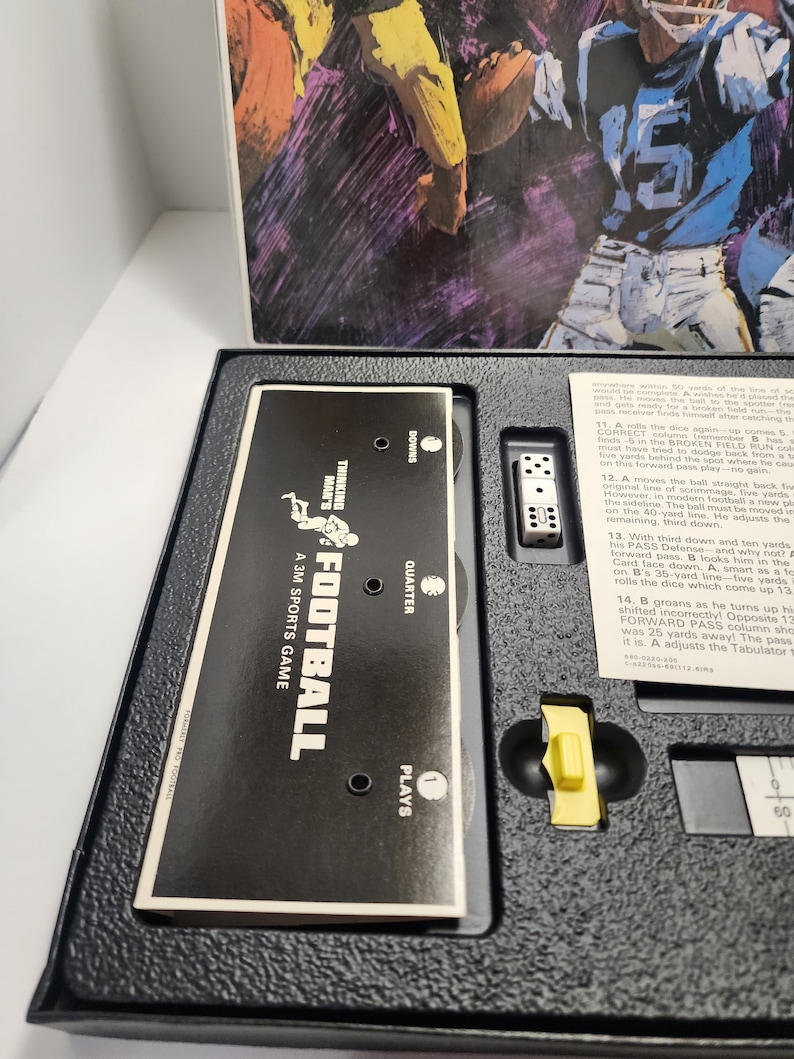 Peut inclure: Un jeu de football vintage 3M Thinking Man's dans une bo&icirc;te noire. Le plateau de jeu pr&eacute;sente un joueur de football courant avec le ballon. La bo&icirc;te comprend des d&eacute;s, un curseur et un plateau de jeu.