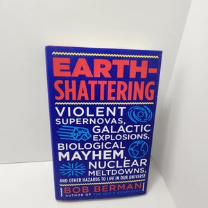 May include: A hardcover book titled "Earth-Shattering" with red and yellow text on a blue background. The book's subtitle lists "Violent Supernovas, Galactic Explosions, Biological Mayhem, Nuclear Meltdowns." The author's name is Bob Berman.