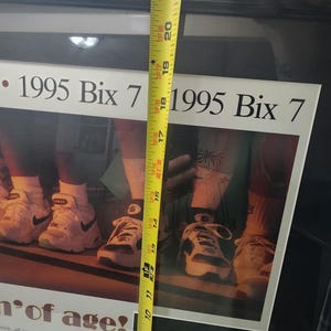 Peut inclure: Impression encadr&eacute;e avec le texte "1995 Bix 7" et une photo de baskets. Un m&egrave;tre ruban jaune indique que le cadre mesure environ 53 cm de haut. L'impression comprend &eacute;galement du texte sur la course Bix 7.
