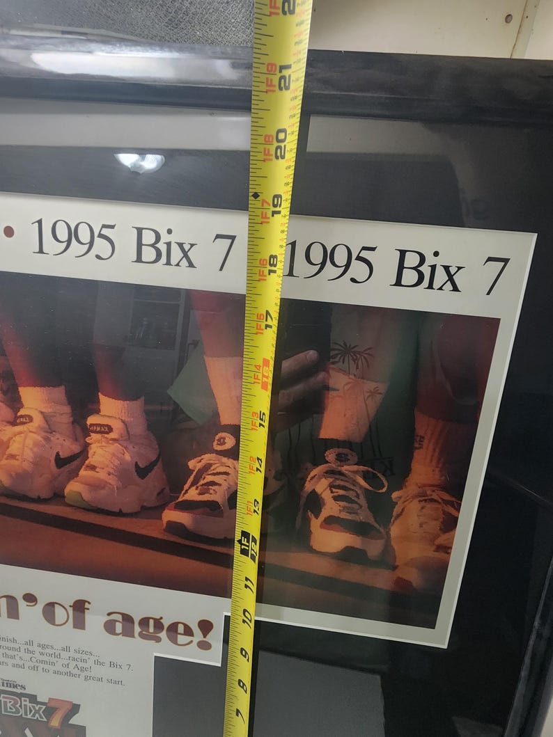 Peut inclure: Impression encadr&eacute;e avec le texte "1995 Bix 7" et une photo de baskets. Un m&egrave;tre ruban jaune indique que le cadre mesure environ 53 cm de haut. L'impression comprend &eacute;galement du texte sur la course Bix 7.