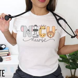 K&ouml;nnte beinhalten: Wei&szlig;es T-Shirt mit einer Grafik von Tiergesichtern, die "NICU nurse" buchstabieren.