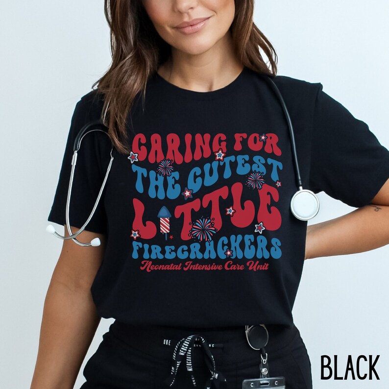 May include: Black t-shirt with a red, white, and blue graphic that says "Caring for the cutest little firecrackers Neonatal Intensive Care Unit".