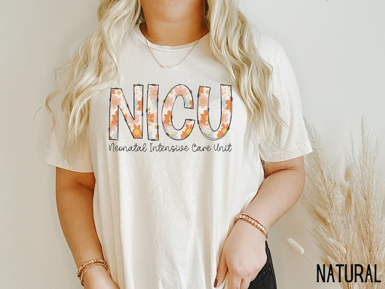May include: A white t-shirt with a floral design that spells out "NICU" and the text "Neonatal Intensive Care Unit" underneath.