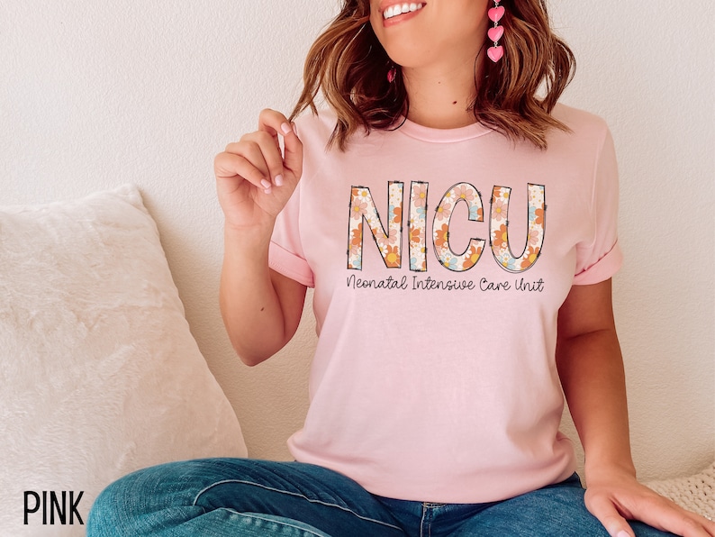 May include: Pink t-shirt with a floral design spelling out "NICU" and the text "Neonatal Intensive Care Unit" underneath.