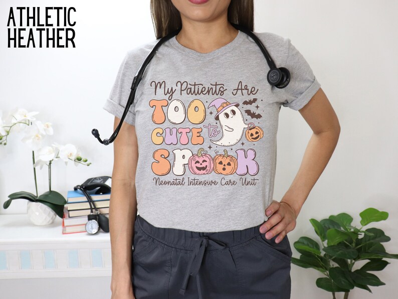 May include: A gray t-shirt with a Halloween-themed design that says "My Patients Are Too Cute To Spook Neonatal Intensive Care Unit". The design features a ghost, pumpkins, and bats.