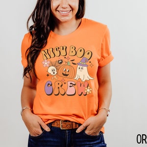 May include: Orange t-shirt with a retro-style graphic that says "Boo Crew" with a pumpkin, ghost, and other Halloween-themed imagery.