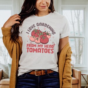Może przedstawiać: Biały t-shirt z grafiką czerwonych pomidor&oacute;w i tekstem "Uwielbiam ogrodnictwo od głowy do st&oacute;p pomidory".