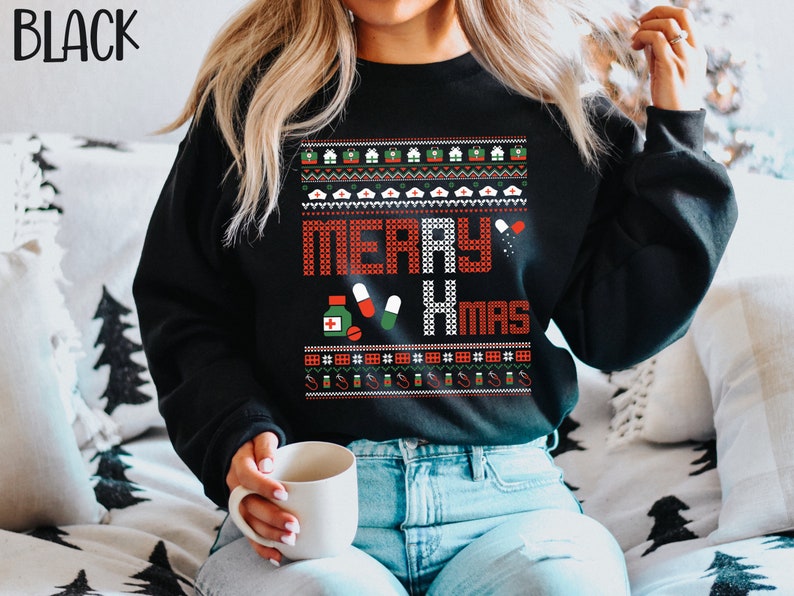 K&ouml;nnte beinhalten: Schwarzer Weihnachtspullover mit rotem und wei&szlig;em Muster und dem Text "Merry Xmas". Der Pullover zeigt verschiedene medizinische Symbole, darunter Pillen, ein Stethoskop und eine Flasche Medizin.