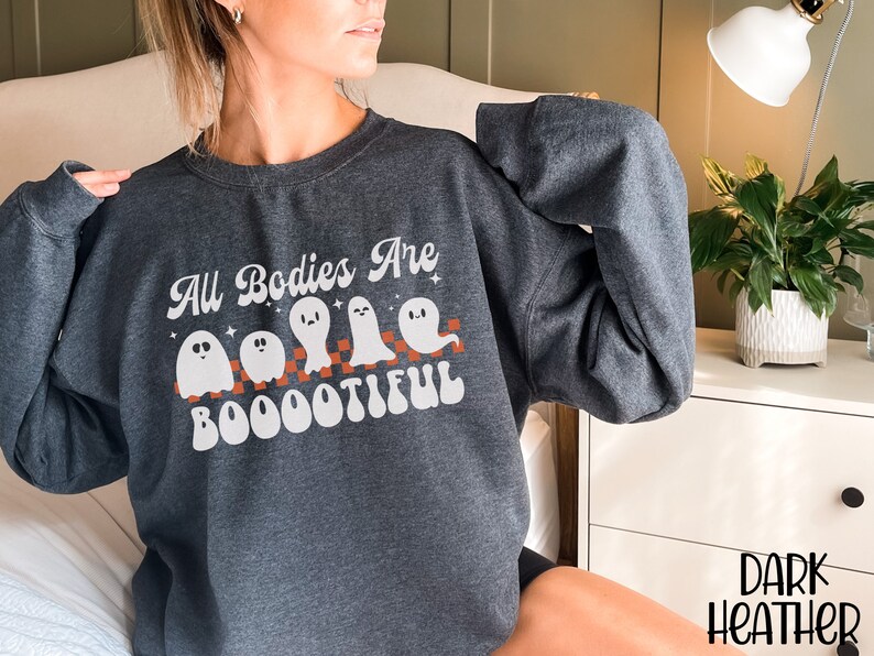 May include: A dark heather grey sweatshirt with a white graphic of ghosts and the text "All Bodies Are Boootiful".