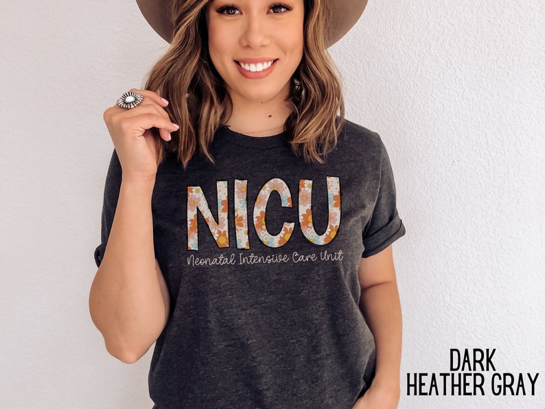 May include: A dark heather grey t-shirt with a floral design spelling out "NICU" and the text "Neonatal Intensive Care Unit".