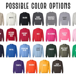May include: A display of crewneck sweatshirts in various colors, including sand, white, black, dark heather, graphite heather, sport grey, ash, maroon, antique cherry red, cherry red, red, heliconia, safety pink, light pink, navy, royal, carolina blue, light blue, forest, military green, irish green, purple, orange, gold, and dark chocolate. The text "POSSIBLE COLOR OPTIONS" is at the top.