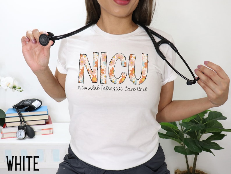 May include: White t-shirt with a floral design that spells out "NICU" and the text "Neonatal Intensive Care Unit".
