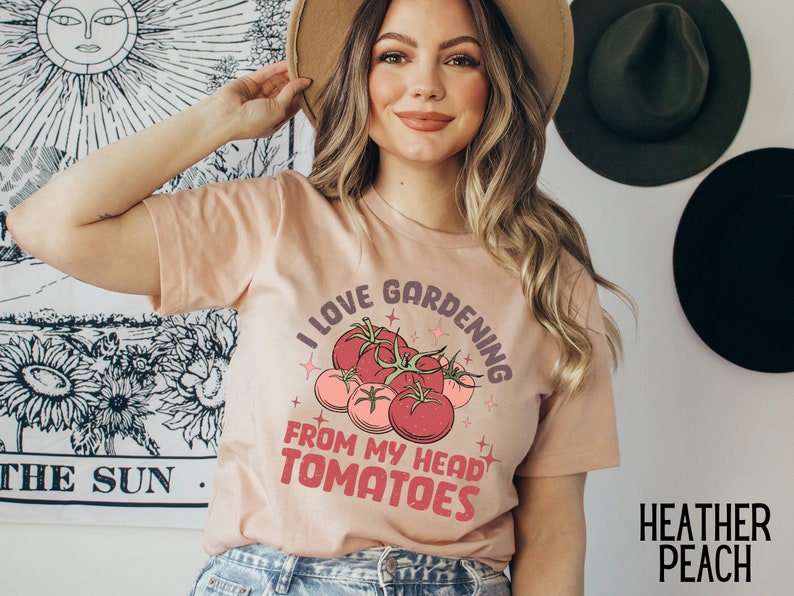 Może przedstawiać: R&oacute;żowy T-shirt z napisem "Uwielbiam ogrodnictwo od głowy do pomidor&oacute;w" i grafiką czerwonych pomidor&oacute;w.